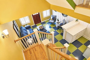 A multi-level living space with a staircase, a sofa set, a dining area, and a kitchen. - The Charleston | Pool • Hot Tub • Lake • Free Golf (Holland)