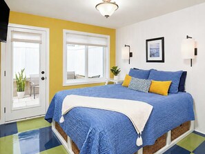 Une chambre à coucher avec un grand lit, une fenêtre, une porte et un luminaire au plafond.