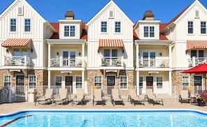 Ett hotell med pool, flera balkonger och utomhusområden med sittplatser.