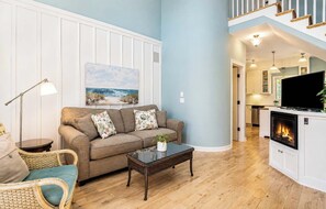 A living room with a sofa, coffee table, and a fireplace. - The Hampton | Pool • Hot Tub • Lake • Free Golf (Holland)