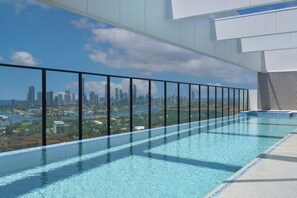 Ein Infinity-Pool auf dem Dach mit Blick auf die Stadtlandschaft.