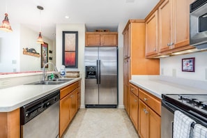 Eine Küche mit Holzausstattung, Edelstahlgeräten und einem Geschirrspüler.