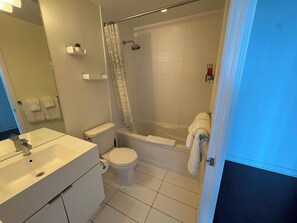 A bathroom with a toilet, sink, and bathtub. - Modern Core 1BR Oasis Walk to Rogers Centre! (Toronto)