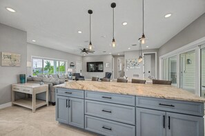 A spacious kitchen with a large island, grey cabinetry, and pendant lighting. - New Remodel/Short Walk To Clearwater Beach/Pool (Clearwater)