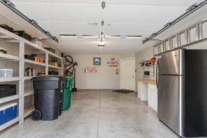 A clean, well-organized kitchen with stainless steel appliances, storage shelves, and a clear path to the exit. - Ridgecrest Lakeview Retreat (Whitefish)