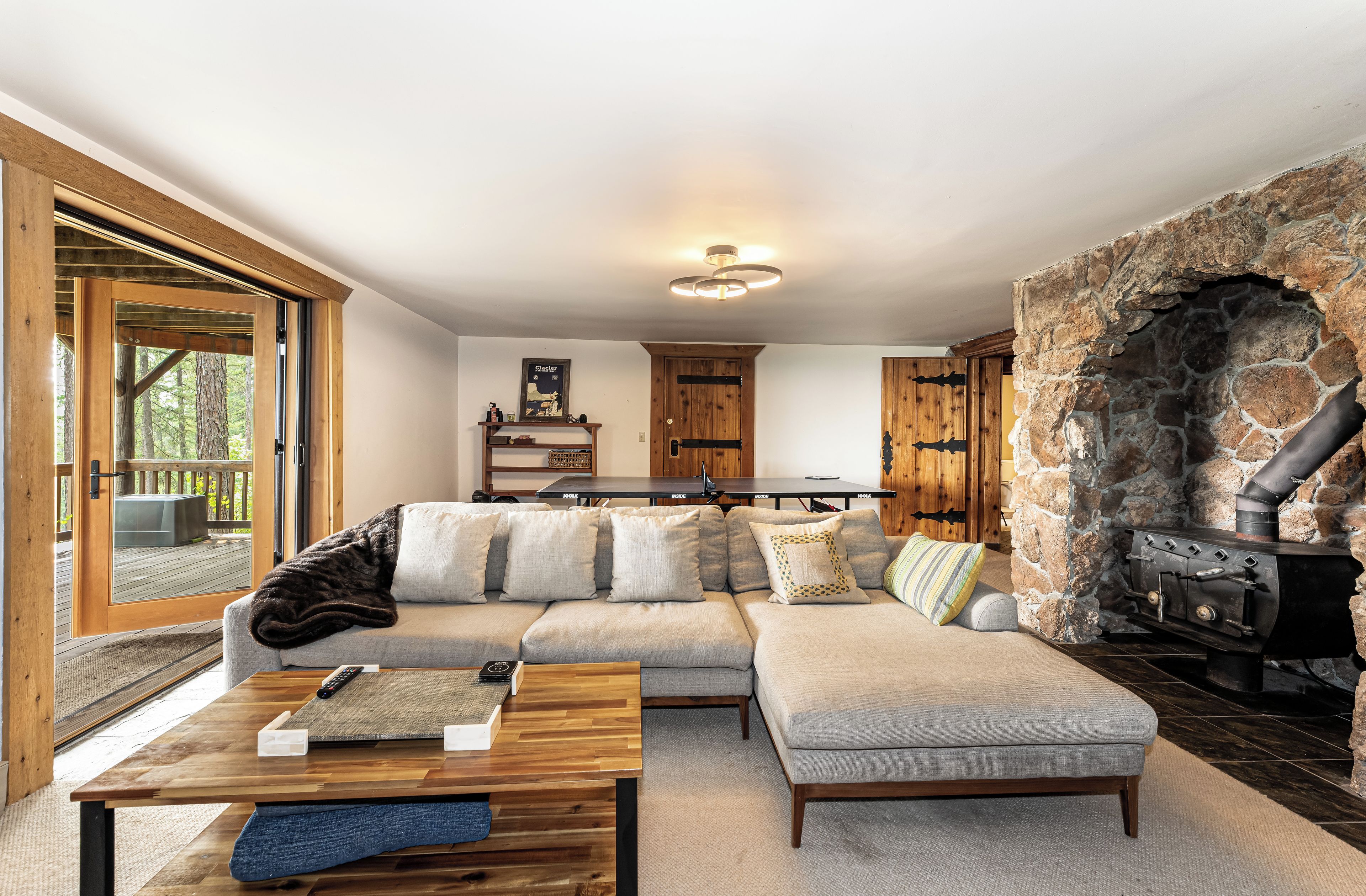 A cozy living room with a sectional sofa, a coffee table, and a stone fireplace.