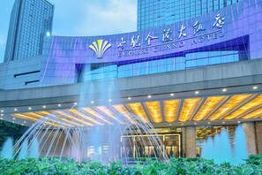 El exterior del Hotel Empark Grand, con una entrada destacada y una fuente ornamental al frente.
