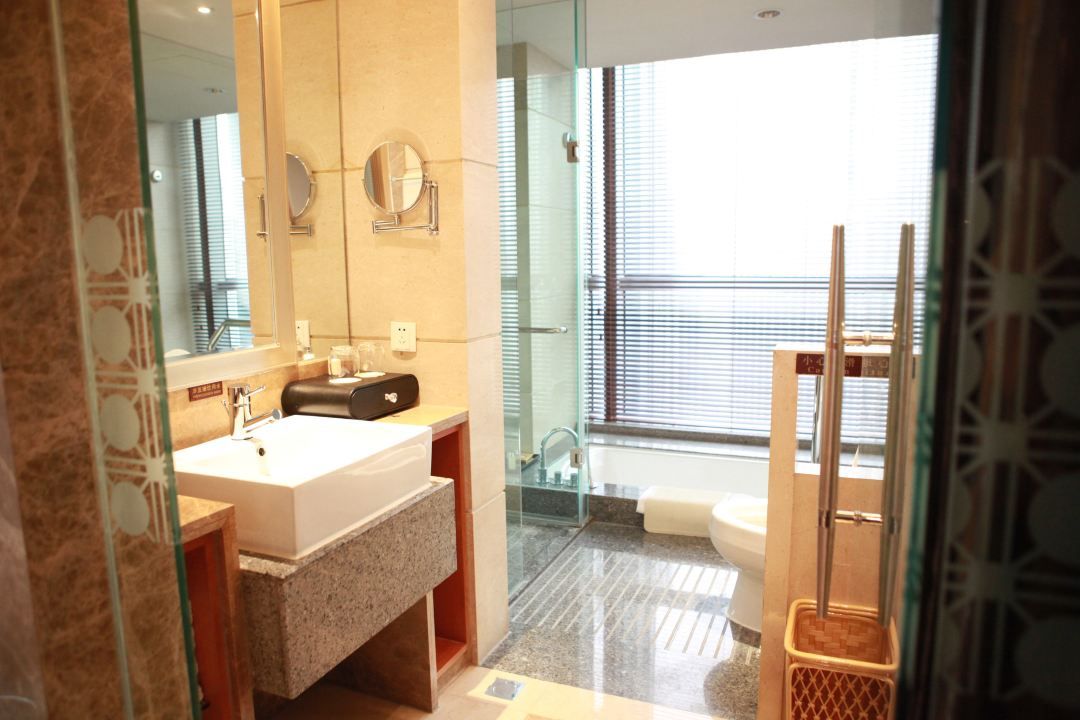 Un baño moderno con un espejo grande, un lavabo y una zona de ducha.