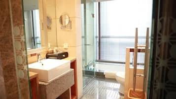 Un baño moderno con un espejo grande, un lavabo y una zona de ducha.