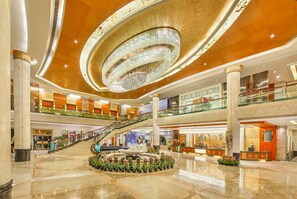A multi-level atrium with a grand staircase, a central fountain, and a chandelier. - Empark Grand Hotel Guiyang (Guiyang)