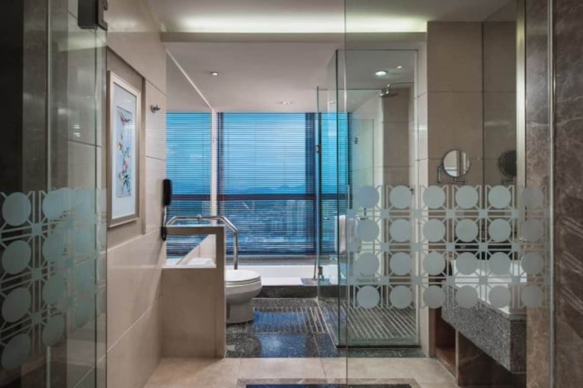 Un baño moderno con mampara de vidrio, inodoro, lavabo y zona de ducha.