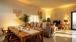 A modern living room with a wooden dining table, sofa, and TV. - Bohemian Chic Villa Brand New 2BR with Private Pool, Next To Obsidian & Paddle (Kabupaten Badung)