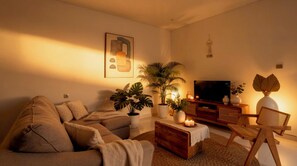 A cozy living room with a sofa, coffee table, potted plants, a television, and a lamp. - Bohemian Chic Villa Brand New 2BR with Private Pool, Next To Obsidian & Paddle (Kabupaten Badung)