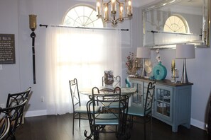 A dining area with a chandelier, a table with chairs, a cabinet with decorative items, and a large mirror. - Spacious 5-bedroom house in lovely Oxford with AC comfort (Oxford)