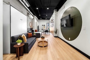 Ein modernes Interieur mit einer Couch, einem Couchtisch und einer großen, runden Wandgestaltung.