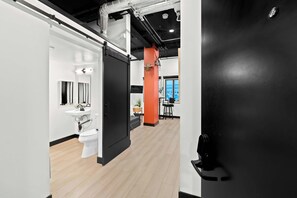 A modern interior with a black door, a white sink, and a view of the sea through a window. - Feel Downtown Energy Near Petco Park & Top Dining! (San Diego)