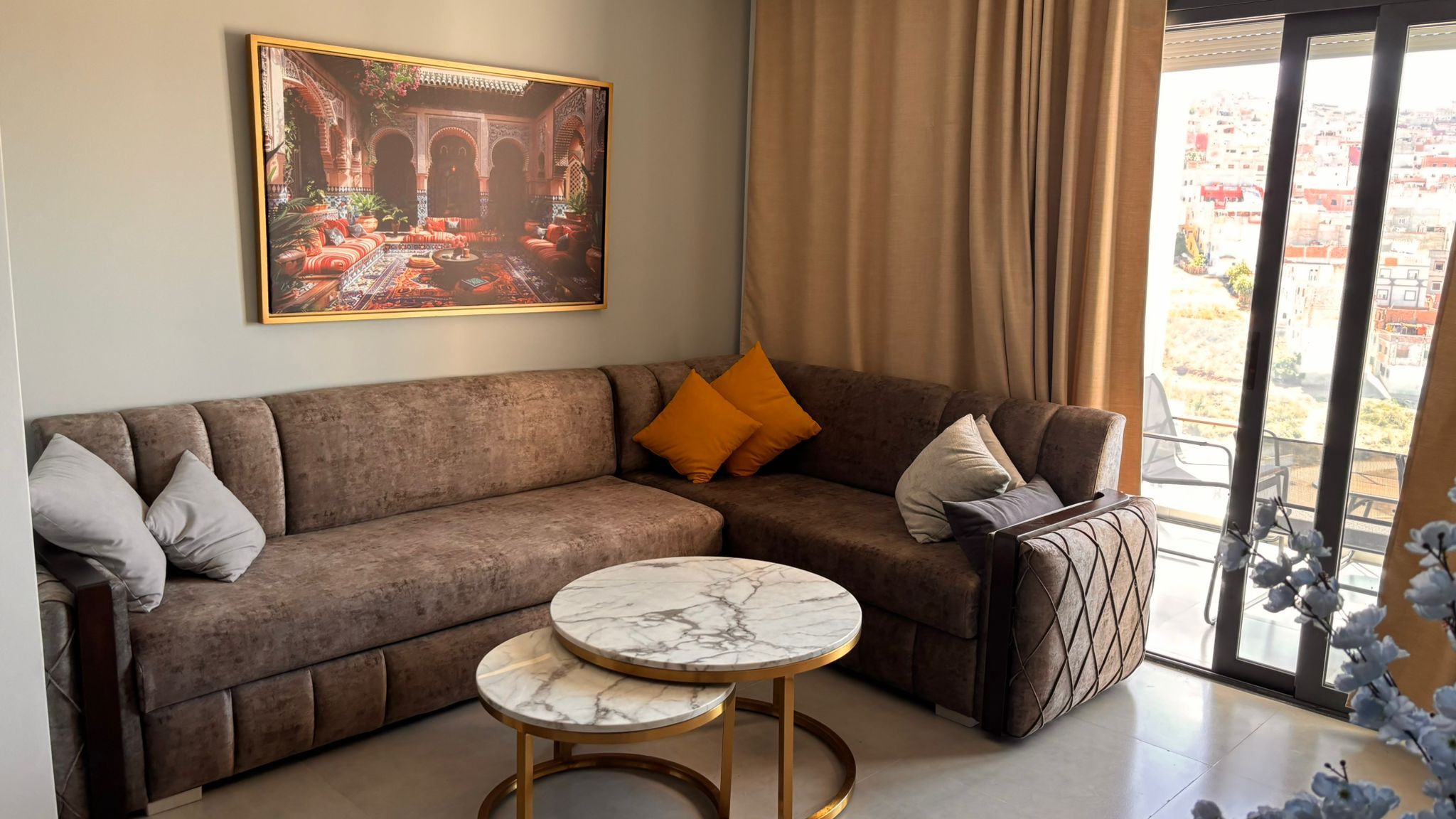 Ein Wohnzimmer mit einer Couch, einem Marmortisch und einem Bild von einem Innenhof.