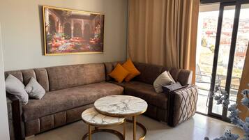 Ein Wohnzimmer mit einer Couch, einem Marmortisch und einem Bild von einem Innenhof.