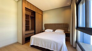 Un dormitorio con cama, armario y ventana.