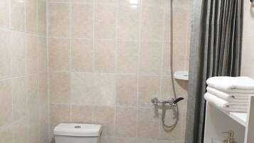 Un bagno piccolo con il water, la doccia e il lavandino.