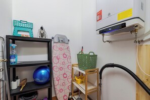 A laundry area with an iron, a blue exercise ball, a green basket, and a water heater. - Brisa do Tejo, By Home Match (Alcochete)