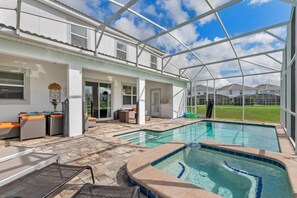 A covered outdoor swimming pool area with lounge seating and a patio. - 5 Bed/4.5 Bath Town House Champions Gate Resort! 5 Bedroom Villa (Davenport)