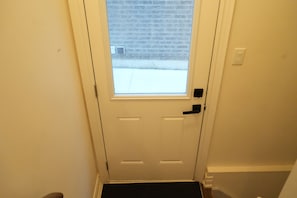 A white door with a small window, a doorknob, and a doorbell. - Cozy Basement Suite in Brampton | Modern & Central (Brampton)