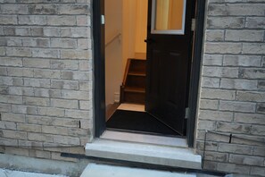 A doorway leading to a staircase with a black mat at the entrance. - Cozy Basement Suite in Brampton | Modern & Central (Brampton)