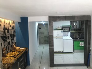 A modern kitchen with a refrigerator, stove, and green cabinets.
