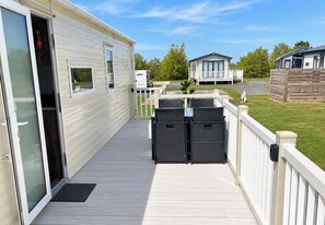 A mobile home with a deck, a white fence, and a small porch area. - Grange Park 2-Bed Caravan, Sleeps 6 with Parking (Mablethorpe)