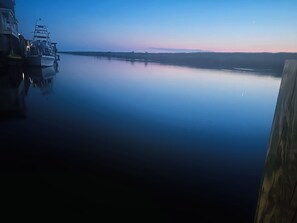 A calm body of water with a dock and a boat.
