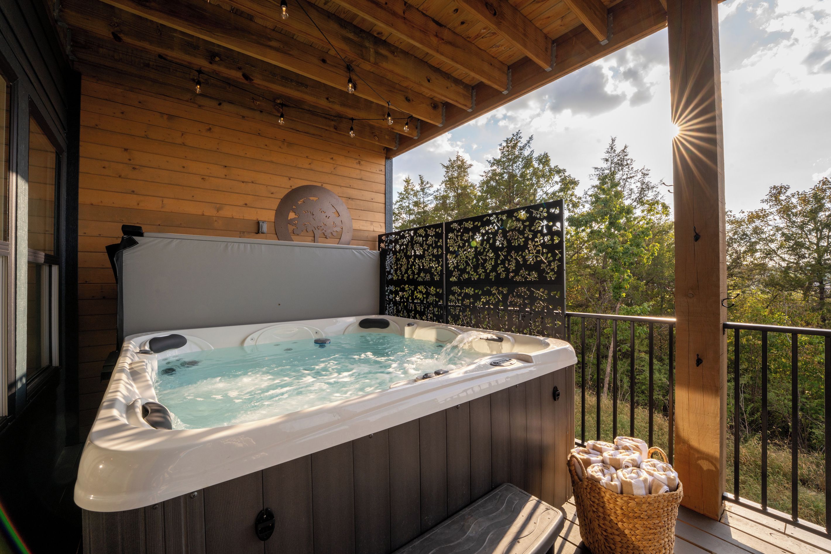 Your private hot tub is ready for long soaks after a day in Branson, tucked beneath the covered deck for added privacy and shade.