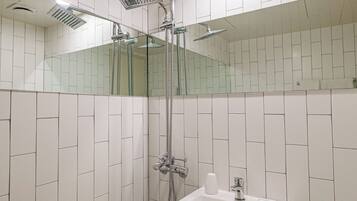 A modern bathroom with a shower, sink, and toilet.