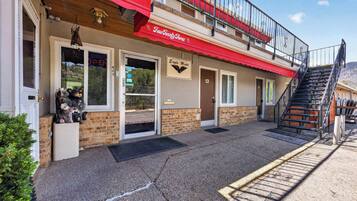 A hotel with a red awning, a staircase, and a sign for the Eagle Motel.