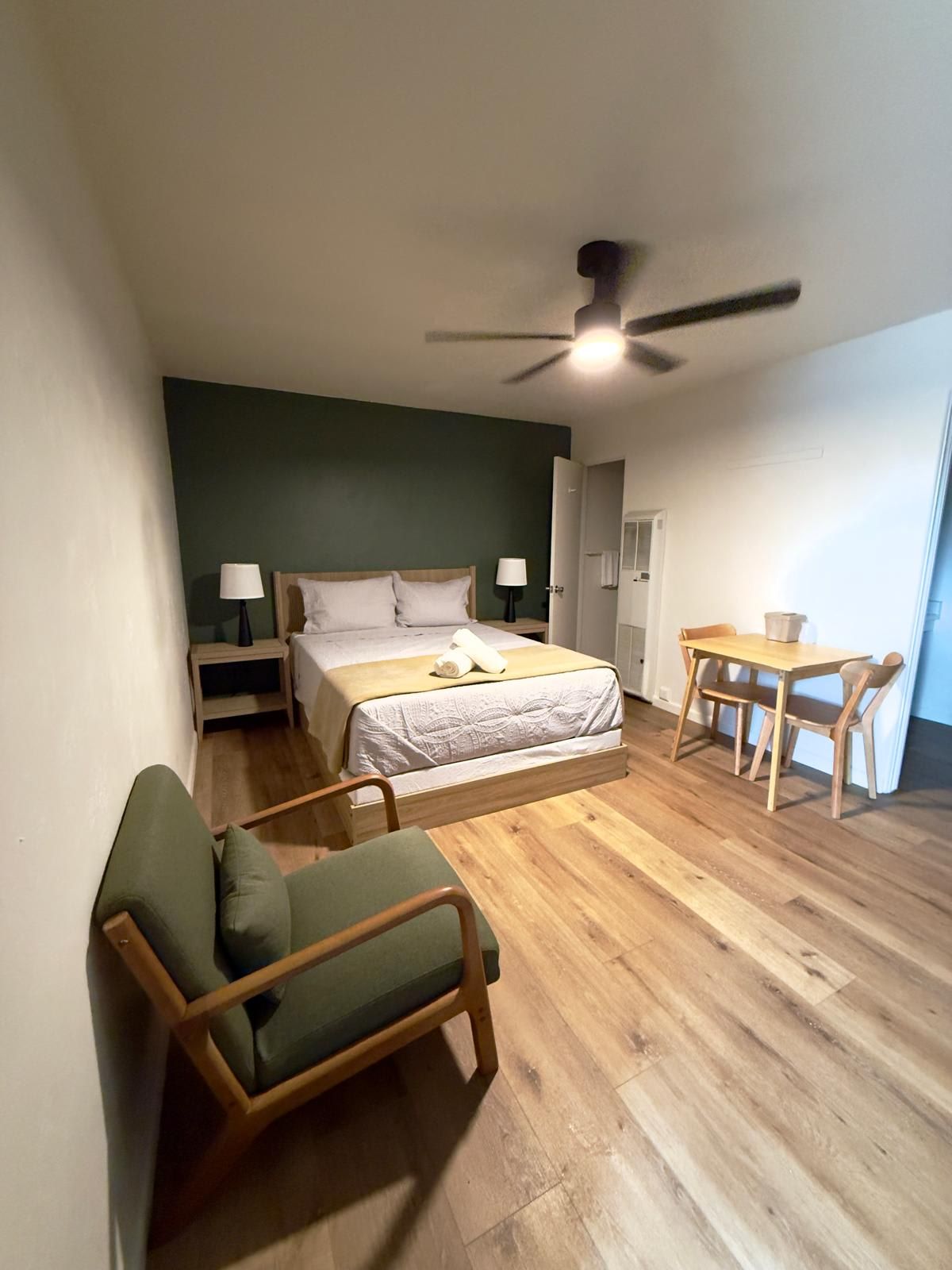 Une chambre à coucher avec un lit, des tables de chevet, un bureau et une chaise.