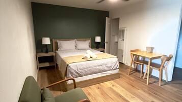 Une chambre à coucher avec un lit, des tables de chevet, un bureau et une chaise.
