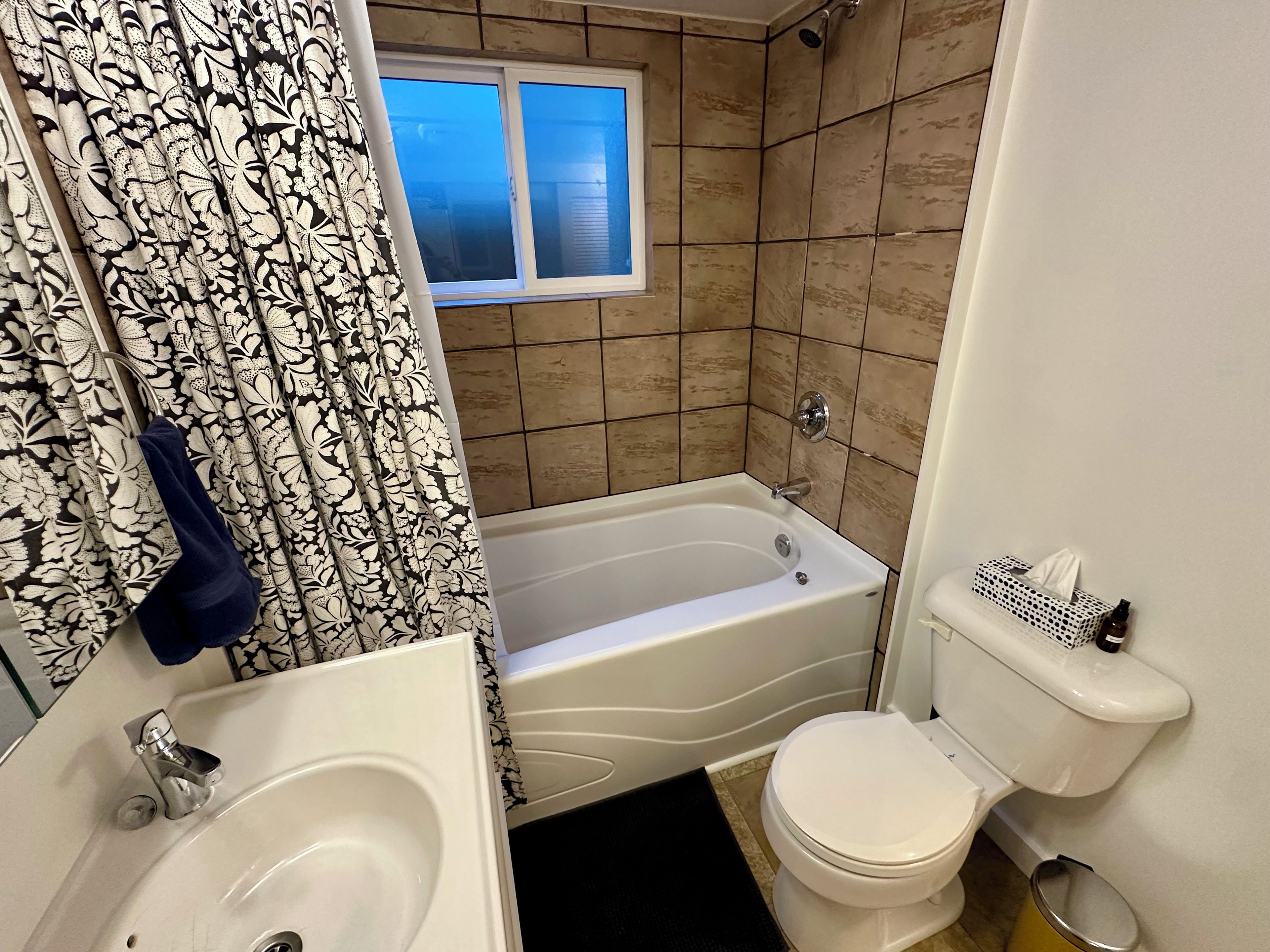 A bathroom with a bathtub, toilet, and sink.