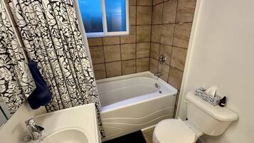A bathroom with a bathtub, toilet, and sink.
