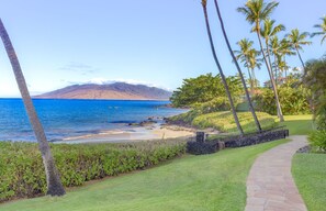 A coastal pathway with a view of the ocean and a mountain in the distance. - Wailea Ground-Floor 2BR Condo on Polo Beach with Stunning Ocean Views! (Kihei)