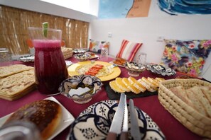 A dining table with various food items, including bread, fruit, and a beverage.