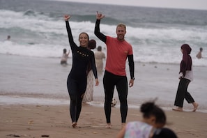 A beach scene with people walking and standing. - Waves Hunter Surf House - Anza (Agadir)