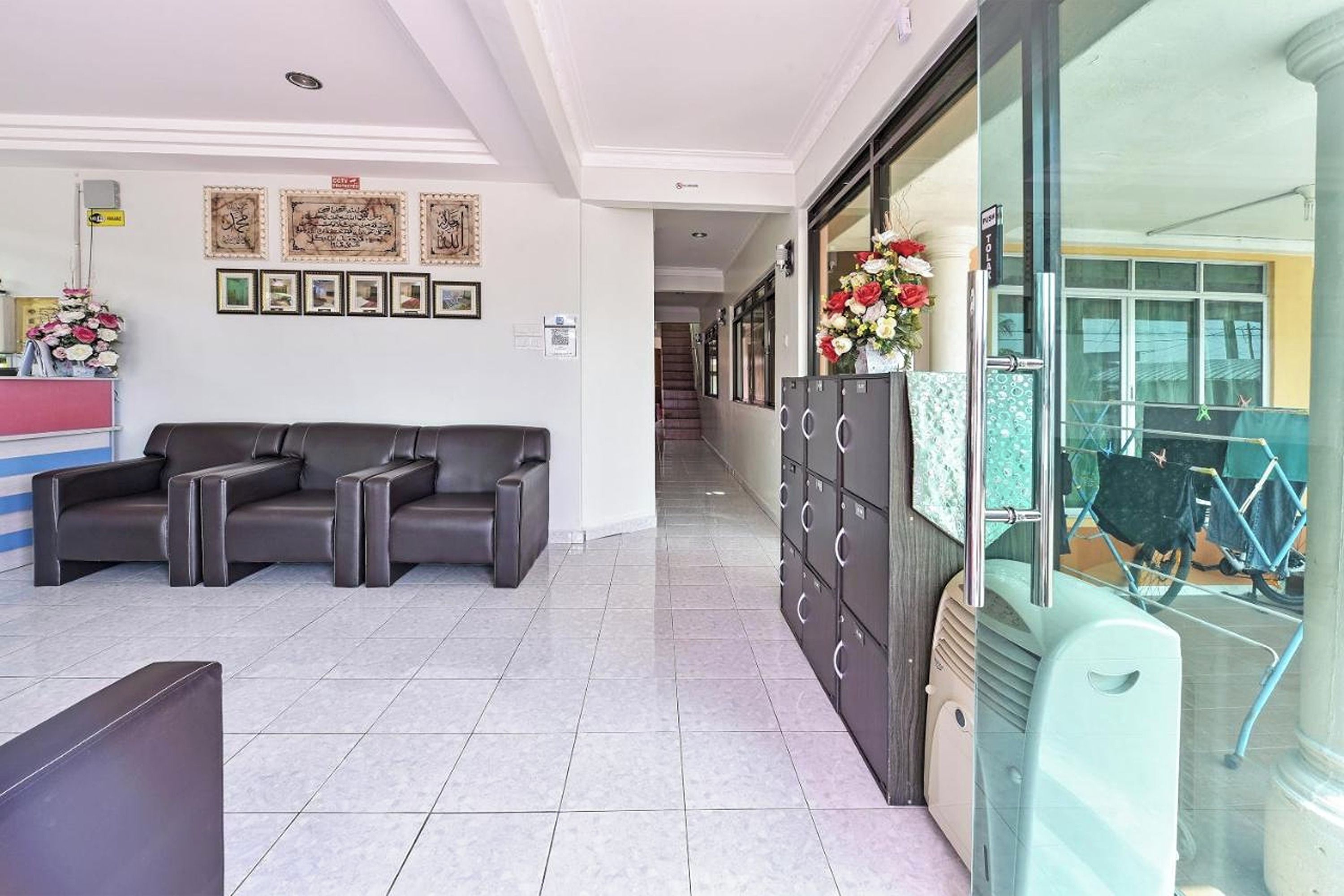 Un vestíbulo de hotel con una recepción, un sofá y una pared con cuadros enmarcados.