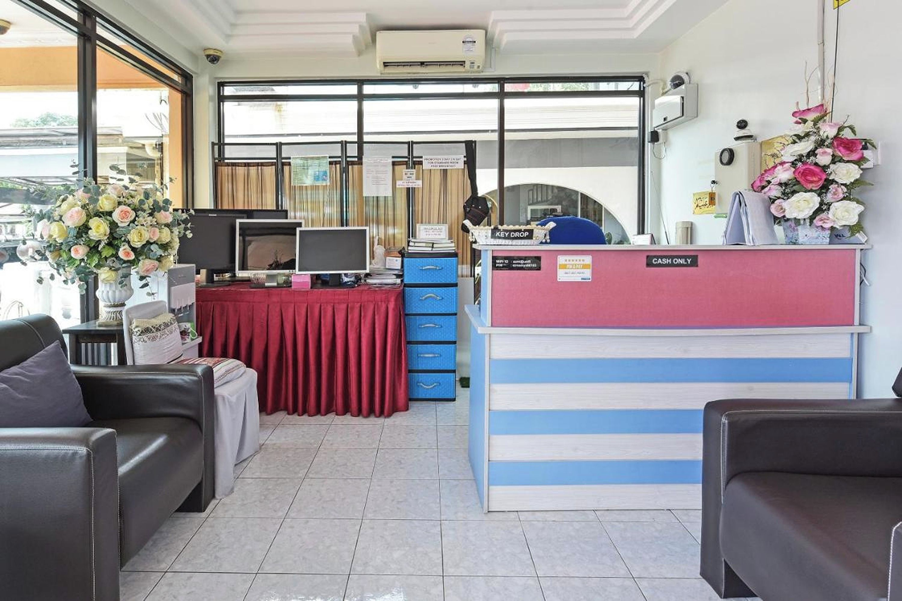 A reception area with a desk, computer, and a 'CASH ONLY' sign.