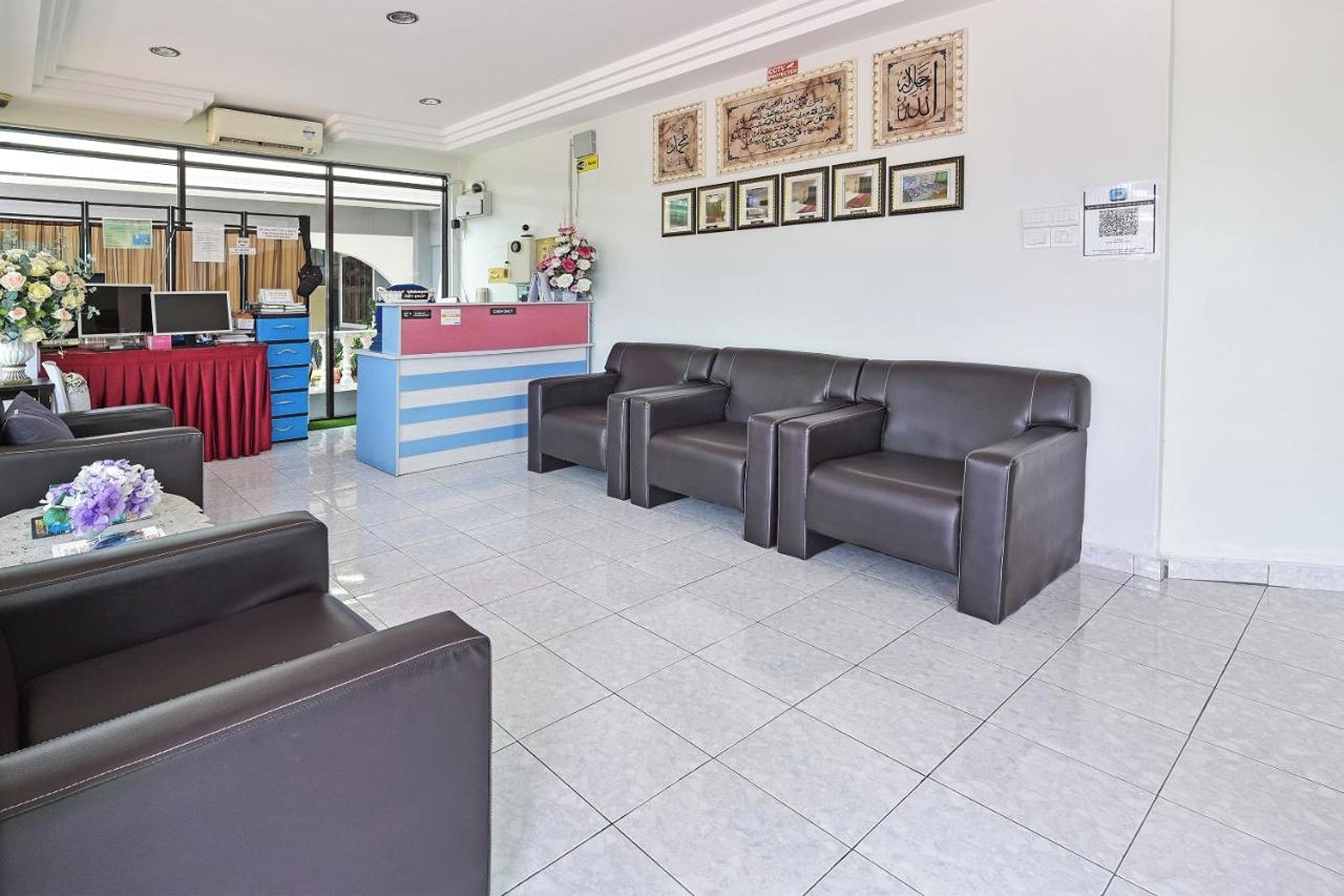 Zona de recepción con mostrador, un sofá y una silla.