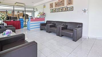 Zona de recepción con mostrador, un sofá y una silla.