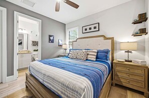 A bedroom with a bed, bedside tables, a nightstand, a lamp, and a window with blinds. - A Harbour's Walk |Gulf Access |Pool & Spa |Game Room (Cape Coral)