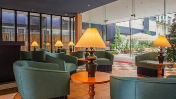Eine Lobby mit Sitzgelegenheiten, Lampen und einem Schachbrettmuster-Boden.