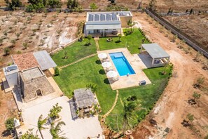 Ein modernes Haus mit Schwimmbad, Solaranlage und gepflegtem Rasen.