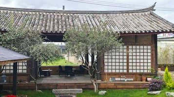 A traditional Japanese building with a tiled roof, a wooden deck, and a stone pathway leading to the entrance.