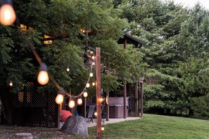 A patio area with outdoor seating, a pergola, and string lights.